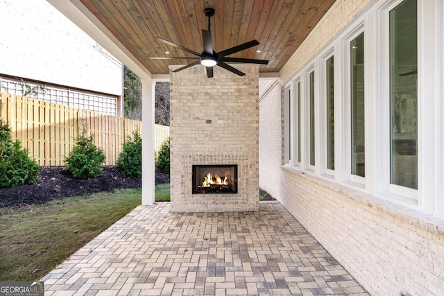 view of patio featuring an outdoor brick fireplace and ceiling fan