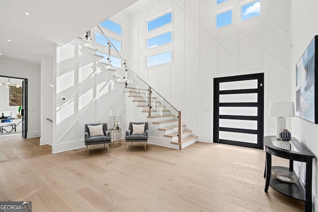 entrance foyer with light wood-type flooring and a high ceiling