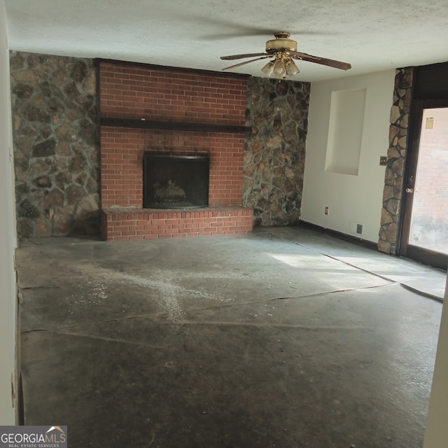 unfurnished living room featuring a brick fireplace, ceiling fan, and a textured ceiling