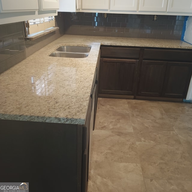 kitchen featuring white cabinets, tasteful backsplash, and light stone countertops