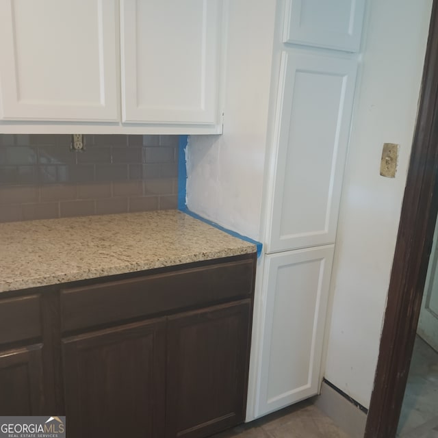 kitchen with white cabinets, backsplash, and light stone countertops