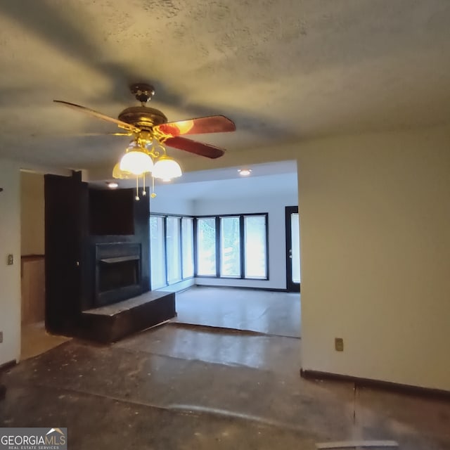 unfurnished living room featuring concrete flooring and ceiling fan