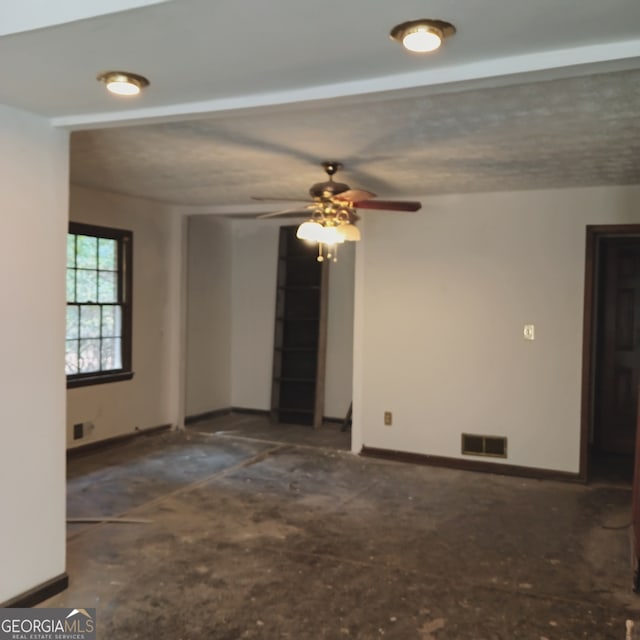 empty room with a textured ceiling and ceiling fan