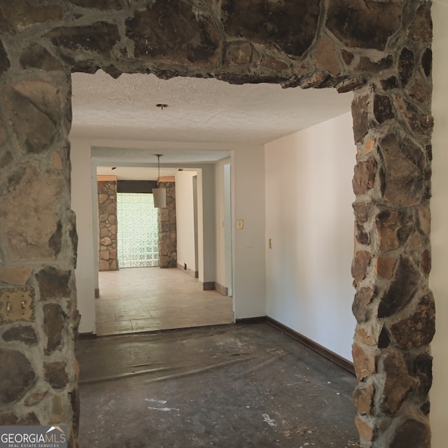 hall featuring a textured ceiling