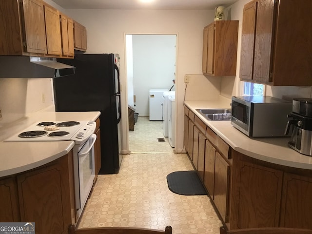 kitchen featuring separate washer and dryer and electric range