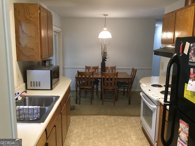 kitchen with black fridge, white electric stove, decorative light fixtures, and sink