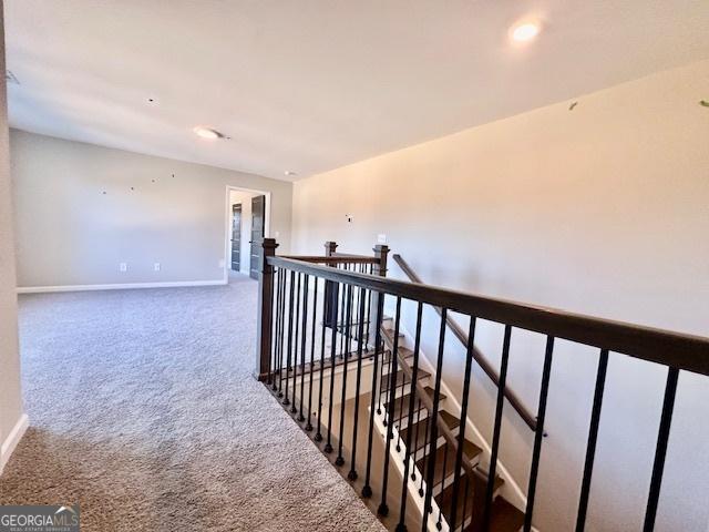 corridor with an upstairs landing, carpet flooring, baseboards, and recessed lighting