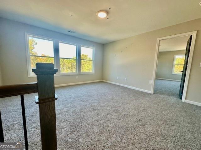 unfurnished room featuring baseboards and carpet floors