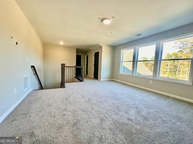 empty room featuring baseboards and carpet