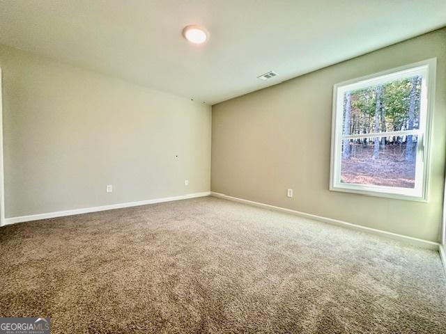 carpeted spare room with baseboards