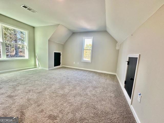additional living space with vaulted ceiling, carpet flooring, and baseboards