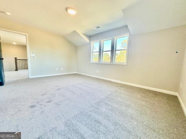 bonus room with baseboards, carpet floors, and vaulted ceiling