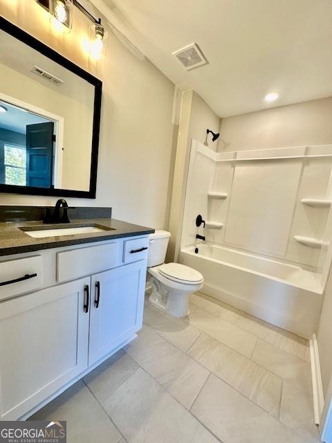 bathroom with toilet, vanity, washtub / shower combination, and tile patterned floors
