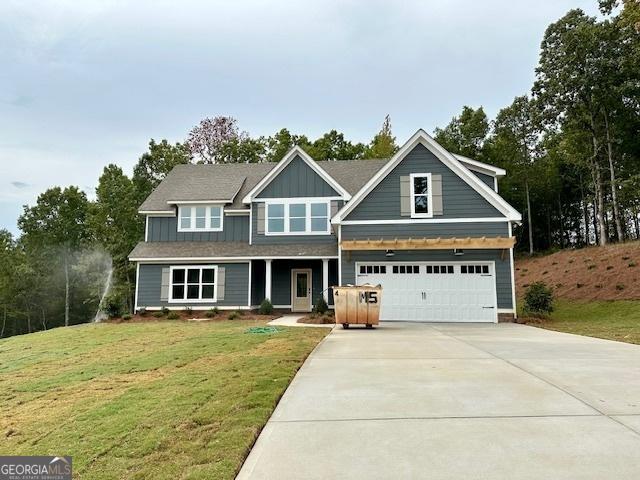 craftsman-style home featuring driveway, a garage, a front yard, and board and batten siding
