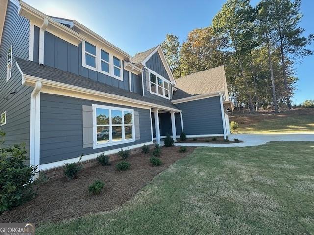 view of front of property featuring board and batten siding and a front yard