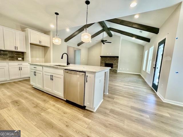 kitchen with dishwasher, a sink, ceiling fan, white cabinets, and light wood-style floors