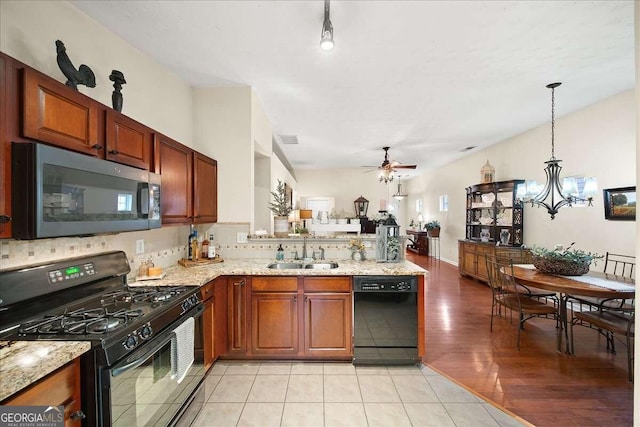 kitchen with sink, black appliances, decorative backsplash, decorative light fixtures, and kitchen peninsula