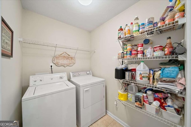 clothes washing area featuring light tile patterned floors and independent washer and dryer