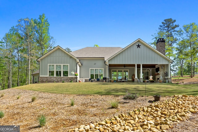 back of property with a yard and ceiling fan