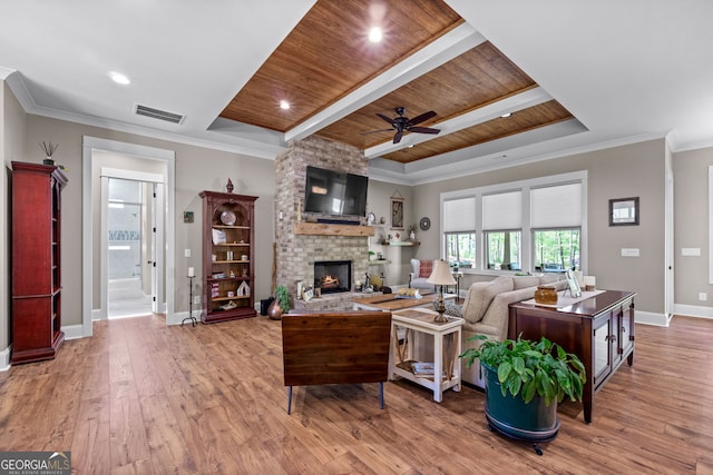 living room with a brick fireplace, wood ceiling, a raised ceiling, ceiling fan, and hardwood / wood-style floors