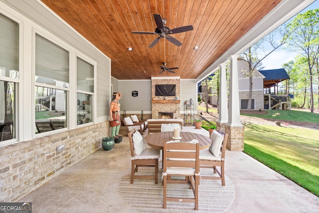 view of patio / terrace with an outdoor stone fireplace and ceiling fan