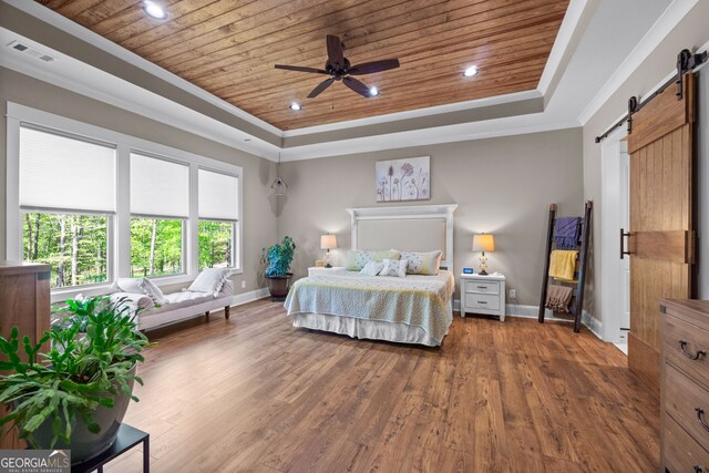 bedroom with dark wood-type flooring, ceiling fan, a barn door, a tray ceiling, and wood ceiling