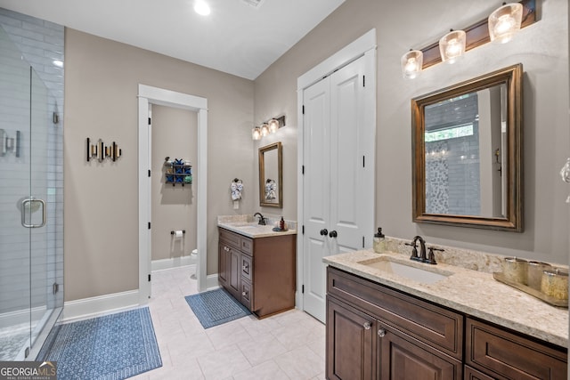 bathroom featuring tile patterned flooring, vanity, toilet, and an enclosed shower