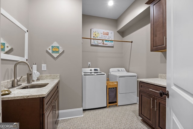 washroom with washing machine and dryer, sink, and cabinets