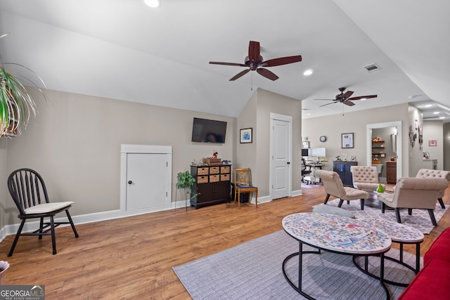 living room featuring light wood-type flooring, vaulted ceiling, and ceiling fan