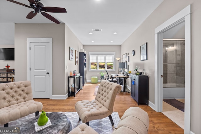 living room with ceiling fan and light hardwood / wood-style flooring