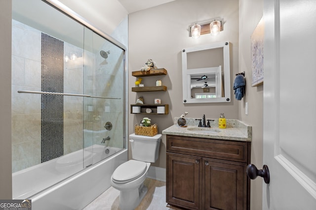 full bathroom featuring toilet, combined bath / shower with glass door, and vanity