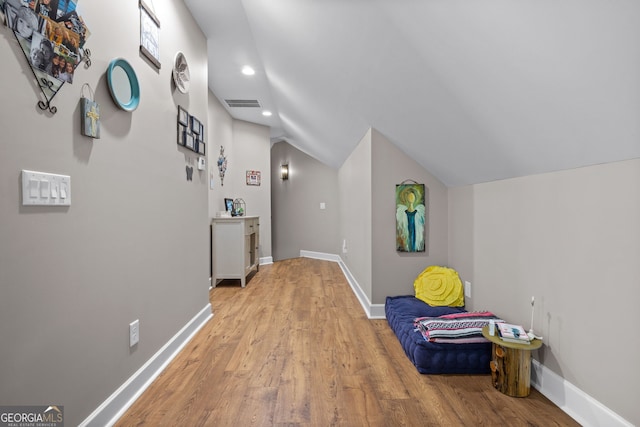 hall featuring light hardwood / wood-style floors and lofted ceiling