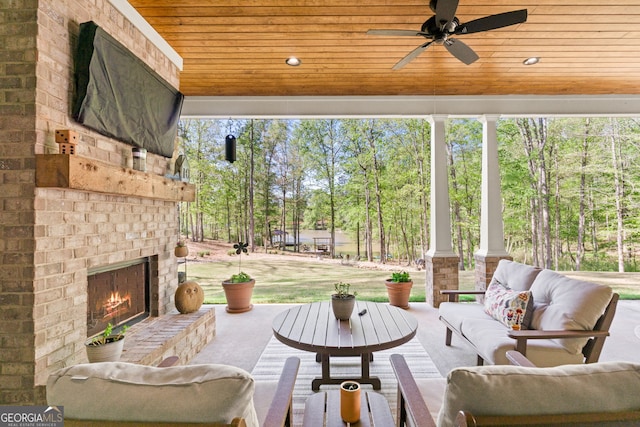 view of patio with an outdoor living space with a fireplace and ceiling fan