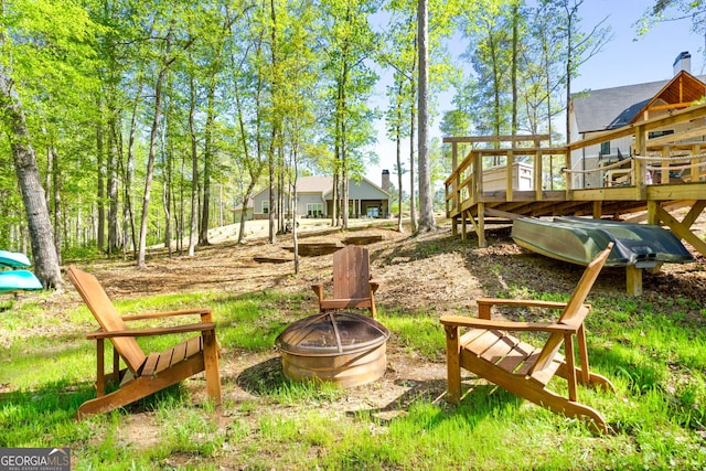 view of yard with an outdoor fire pit and a wooden deck