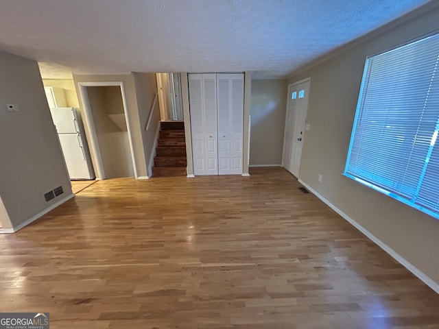 interior space featuring a textured ceiling and light wood-type flooring