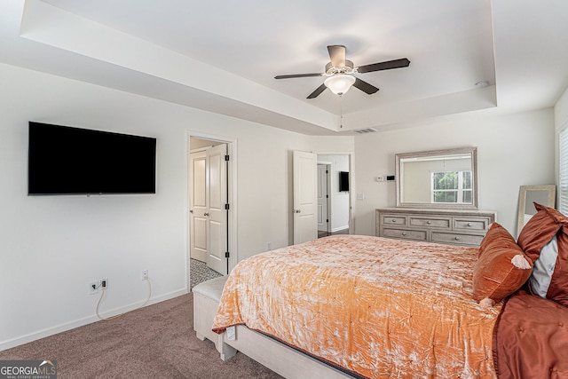 bedroom with ceiling fan, a raised ceiling, and carpet floors