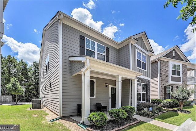 view of front of property featuring a front yard and cooling unit