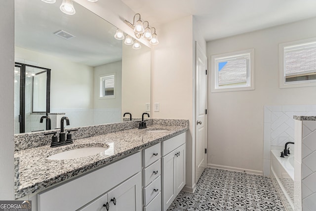 bathroom featuring vanity, a bath, and tile patterned floors