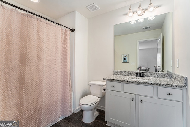 full bathroom featuring vanity, hardwood / wood-style floors, shower / tub combo, and toilet