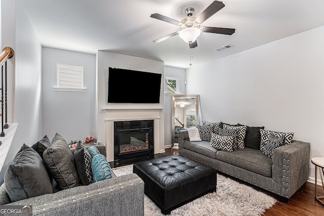 living room with ceiling fan and dark hardwood / wood-style flooring