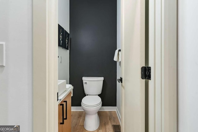 bathroom with vanity, hardwood / wood-style flooring, and toilet