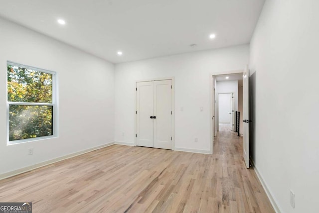 unfurnished bedroom featuring light hardwood / wood-style flooring and a closet