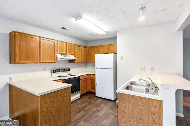 kitchen with white appliances, a textured ceiling, kitchen peninsula, and dark hardwood / wood-style floors