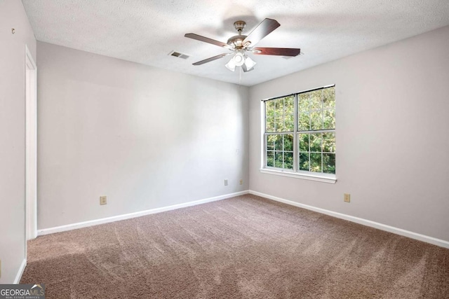 spare room featuring a textured ceiling, carpet, and ceiling fan