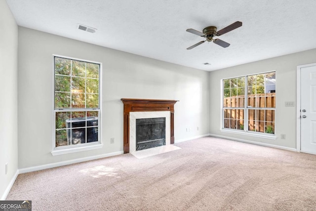 unfurnished living room with carpet floors, a textured ceiling, and ceiling fan