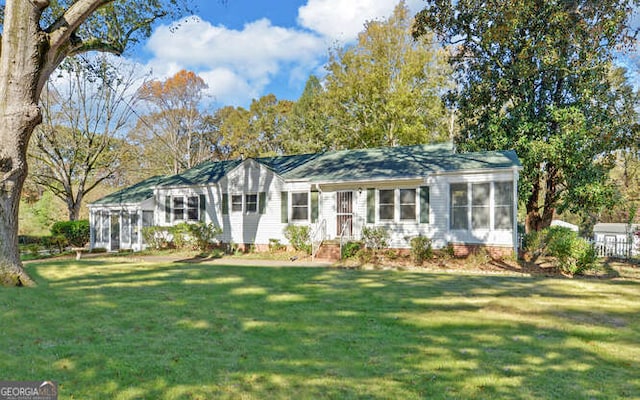 view of front of home with a front yard and a sunroom