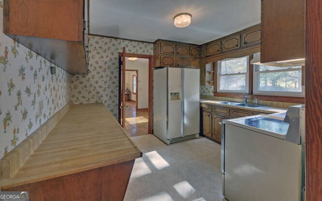 kitchen with white fridge with ice dispenser, stove, and sink