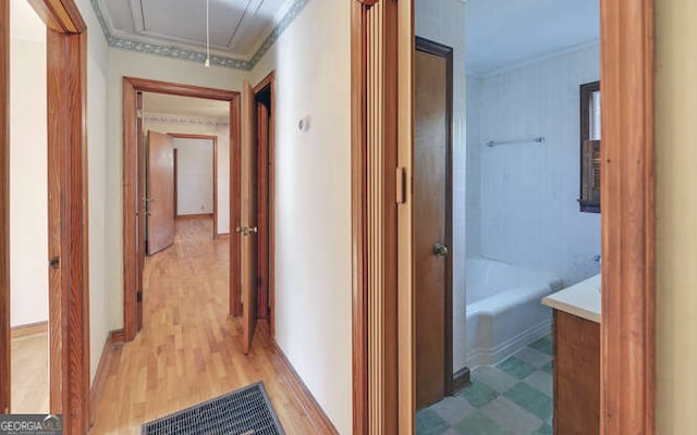 hall featuring light wood-type flooring and ornamental molding