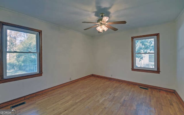 unfurnished room featuring hardwood / wood-style flooring, ceiling fan, and a healthy amount of sunlight