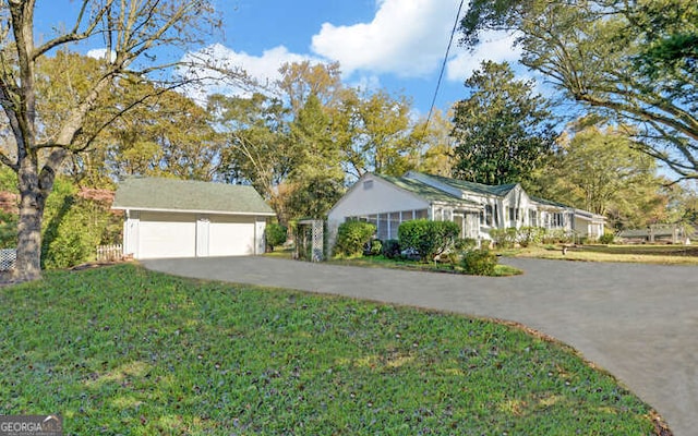 ranch-style house with a garage, an outdoor structure, and a front lawn